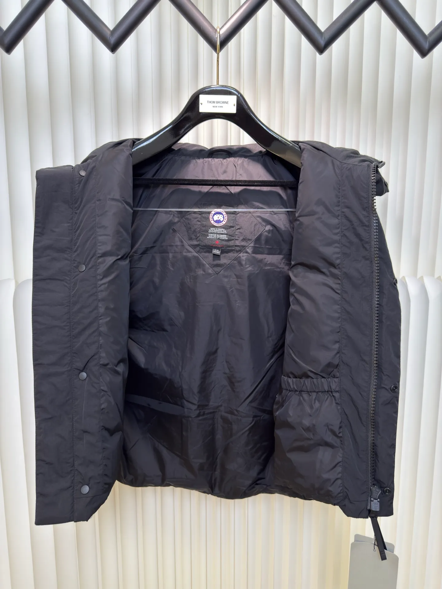 P760 Big Goose Logo Hooded Down Vest is made of high-quality protective nylon fabric, which not only enhances the wear resistance of the surface, but also takes into account wind resistance, ensuring excellent performance in various harsh weather conditions.  90 national standard high-quality white duck down: selected high-loft down, weighing 170g, light and warm, with excellent temperature locking performance and good resilience.  Three-dimensional quilting process: Precision thread reinforcement to prevent velvet drilling and ensure that the fluffy and resilient elasticity lasts as new.  Details: The ribbon is woven with polyester as the base. The brand letters are decorated on the ribbon through high-precision computer embroidery. The edges of the pattern are clear, the stitches are fine and even, and multiple layers of embroidery thread are stacked to enhance the three-dimensional effect. Size S M L XL